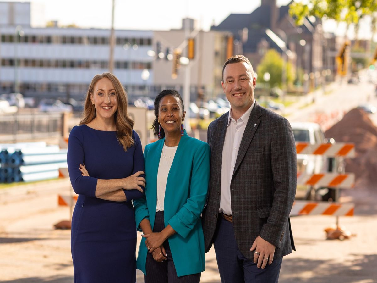 Erik Muckey, June CopperStad and Kadyn Wittman standing together on a downtown Sioux Falls street