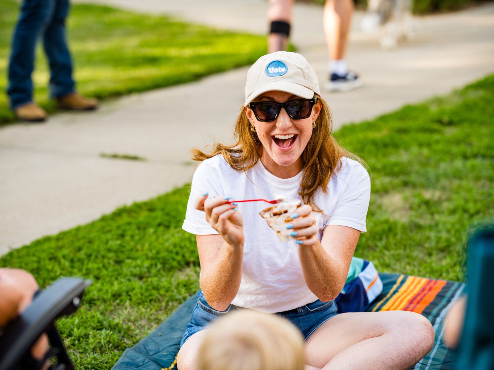 Rep. Kadyn Wittman laughing over a cup of ice cream on a picnic blanket